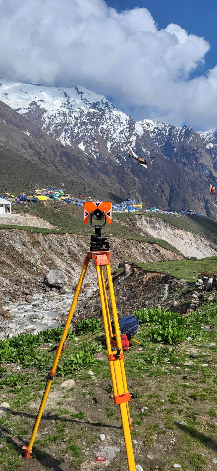 Survey prism target with helicopter and snow peaks behind at Kedarnath